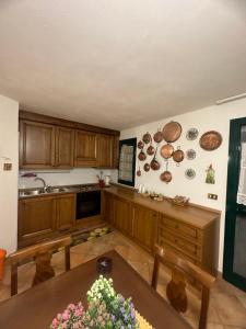 cocina con armarios de madera y mesa de madera en Relax home en San Massimo
