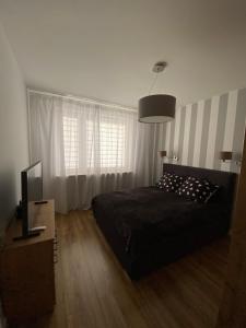 - une chambre avec un lit et une télévision dans l'établissement Fajny apartament z parkingiem, obok metra., à Varsovie
