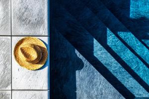 a straw hat sitting next to a swimming pool at Olivenere agriturismo in Lavagna