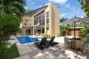 a house with a pool and a table with chairs and an umbrella at Tulum Private Modern Villa-Pool Beds-AC-Internet-Parking-Grill in Tulum +52 photos