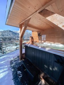 a woman is in a hot tub in a wooden house at Les Trois Chaufatons - Chalets Boutiques in Montriond