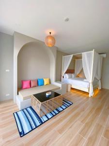 ein Wohnzimmer mit einem Sofa und einem Bett in der Unterkunft Chul Boutique Villa จุล บูทิค วิลล่า in Ban Ba Ngan