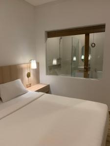 - une chambre avec un lit blanc et un miroir dans l'établissement The Hita Apartement, à Seminyak