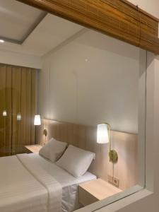 - une chambre avec un lit blanc et deux lampes dans l'établissement The Hita Apartement, à Seminyak
