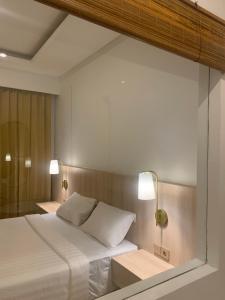 - une chambre avec un lit blanc et deux lampes dans l'établissement The Hita Apartement, à Seminyak