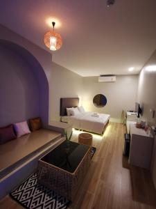 ein Wohnzimmer mit einem Bett und einem Sofa in der Unterkunft Chul Boutique Villa จุล บูทิค วิลล่า in Ban Ba Ngan