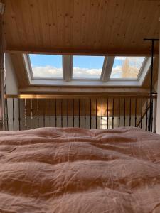 a bed in a room with a large window at B&B De Porrel in Polsbroek