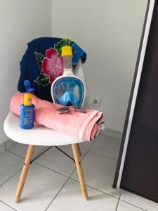 einen Stuhl mit einer Flasche und einem Handtuch darauf in der Unterkunft PERLE DES ANTILLES in Oyster Pond