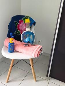 a chair with a bottle and a towel on it at PERLE DES ANTILLES in Oyster Pond