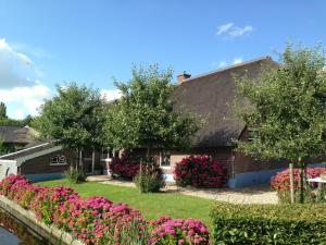 a house with pink flowers in the yard at B&B De Porrel in Polsbroek