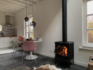 a kitchen and dining room with a stove in a room at B&B De Porrel in Polsbroek