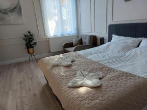 sypialnia z łóżkiem z dwoma białymi butami w obiekcie Castle Apartman **** w mieście Sátoraljaújhely