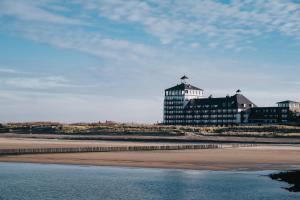 a building on the beach next to the beach at Strandhotel in Cadzand-Bad