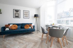 a living room with a blue couch and a table at Connaught House - City Centre - Free Parking & Wi-Fi in Cardiff