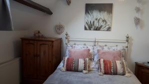 a bedroom with a bed with two pillows on it at LAVENDER COTTAGE in Whitby