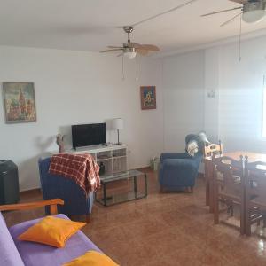 uma sala de estar com um sofá e uma televisão em Apartamento en primera linea de mar. em Múrcia