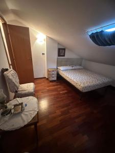 Habitación pequeña con 2 camas y silla en Relax home en San Massimo