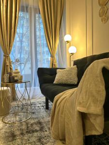 a living room with a black couch and a window at Luxury Mansion in Bucharest