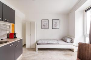 ein weißes Zimmer mit einem Bett und einer Küche in der Unterkunft Apartments Cologne in Köln