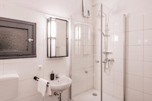 a white bathroom with a sink and a shower at Flats 4 You, Moderne City Wohnung Nähe HBF, DÜ-Messe 20 Min, Netflix, Küche in Duisburg
