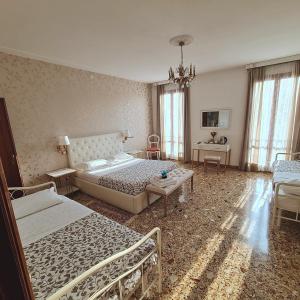 a bedroom with two beds and a chandelier at Venezia Canal View in Venice