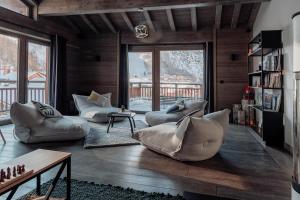 a living room with couches and a large window at Victoria Lodge, Friendly Hotel in Val dʼIsère