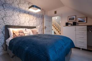 1 dormitorio con 1 cama con edredón azul en Apartament Widok 5, en Piechowice