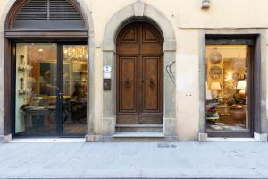 a store front with a wooden door and two windows at Fossi Elegant Apartment in Florence