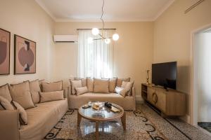 un soggiorno con divano e tavolo di Sofias LemonTree Family House ad Ágios Nikólaos