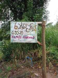 a sign on the side of a dirt road at Randeniya Hena in Teldeniya