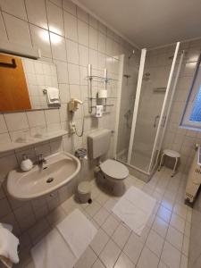 y baño con lavabo, aseo y ducha. en Appartementhaus Henghuber, en Bad Füssing