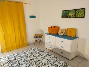 1 dormitorio con vestidor y cortina amarilla en PERLE DES ANTILLES, en Oyster Pond