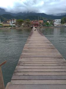 a wooden dock in the middle of a body of water at vista do mar in Angra dos Reis