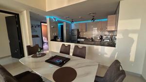 a kitchen and dining room with a table and chairs at Prestigeo Guest House Abu Dhabi in Abu Dhabi