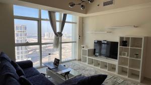a living room with a couch and a large window at Prestigeo Guest House Abu Dhabi in Abu Dhabi