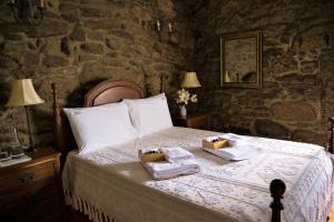 um quarto com uma cama com toalhas e velas em Casa das Infusões - Soalheiro em Melgaço