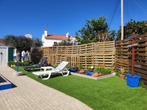 um jardim com duas cadeiras e uma cerca em Alojamento local A Giesta em Sao Sebastiao da Giesteira