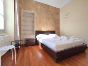 a bedroom with two beds and a table and a chair at Solferino Apartment 2 in Turin