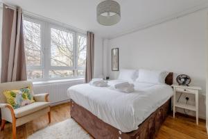 1 dormitorio blanco con 1 cama grande y 1 silla en Cosy 1 Bedroom Flat near Old Street, en Londres