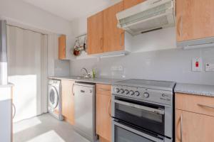 a kitchen with a stove and a dishwasher at Cosy 1 Bedroom Flat near Old Street in London