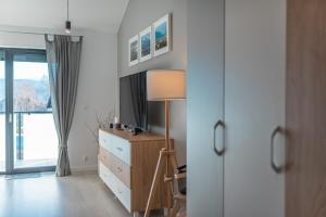 1 dormitorio con vestidor, lámpara y ventana en Apartament Widok 5, en Piechowice