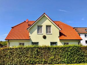 una casa con techo naranja y seto en Am Meer Steuerbord, en Wustrow