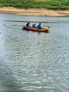 a group of people in a boat on a body of water at Randeniya Hena in Teldeniya