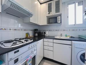 uma cozinha branca com um fogão e um lavatório em Stay U-nique Apartments Lepant em Barcelona