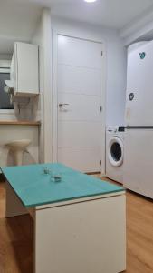 uma cozinha com um balcão azul e uma máquina de lavar roupa em Rosa de los Vientos: Estudios em Cádiz