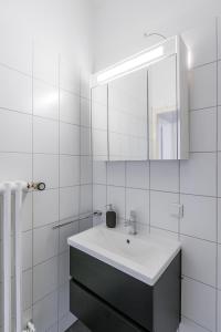 a white bathroom with a sink and a mirror at Flats 4 You, Moderne City Wohnung Nähe HBF, DÜ-Messe 20 Min, Netflix, Küche in Duisburg