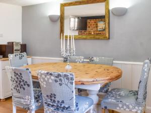 a dining room with a wooden table and chairs at The Farm Cottage in Bognor Regis