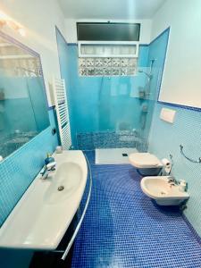 a blue bathroom with a sink and a tub and a toilet at HomeClass in Bari