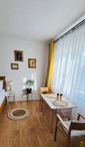 a living room with a table and a window at Warm and cozy studio flat near Straja in Uricani