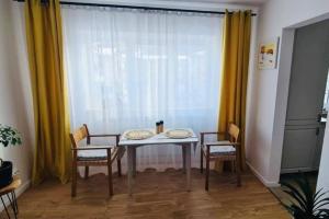 a dining room table with two chairs and a window at Warm and cozy studio flat near Straja in Uricani